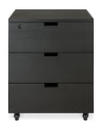 The Billy Drawer Unit - Black Oak by Ethnicraft features three drawers, a lock on the top left drawer, and black wheels. Photographed against a white background, its ideal for sleek, modern office storage.