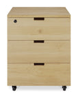 The Ethnicraft Billy Drawer Unit - Oak is a solid oak drawer unit with three soft-closing drawers, black handles, a lock on the top drawer, and four wheels for easy mobility.