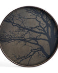 The Black Tree Wooden Tray - Round / Large by Ethnicraft features a striking dark tree branch design on light wood, blending European elegance with bold contrast.