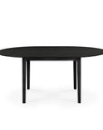 The Ethnicraft Bok Round Extendable Dining Table in black solid oak features four straight legs and is shown against a white background.
