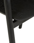 Close-up of the Wooden Stories Inlay Dining Chair | Black Oak, showcasing its Danish-inspired lines, detailed wood grain texture, and smooth, rounded edges on the seat, leg, and frame.