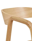 Close-up of the Wooden Stories Inlay Dining Chair | Light Oak, highlighting its smooth, curved backrest and armrest with a natural solid oak grain finish.