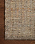 Close-up of the Cornwall Rug - Mocha / Natural by Loloi, showing its textured woven design, organic look, and detailed fibers and stitching along the edge on a wooden floor.