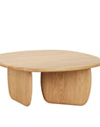 The Eden Coffee Table - Light Oak by Wooden Stories is a round, organic table with a smooth surface and two wide, curved legs that highlight the natural wood grain.
