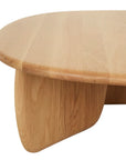 A close-up of the Eden Coffee Table by Wooden Stories showcases its light, solid wood oval design with rounded edges and curved legs, emphasizing the smooth finish and natural grain—capturing Scandinavian simplicity.
