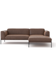 The Department Modular Sofa | Leather • M1 by Wooden Stories is a modern brown sectional with a right-side chaise, slim metal legs, low armrests, and a solid wood base inspired by Danish collections, shown against a plain white background.