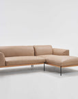 The Wooden Stories Department Modular Sofa | Leather • M1 is a modern beige L-shaped sectional with plush cushions and thin black metal legs, inspired by Danish collections, shown against a plain white background.