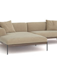 The Wooden Stories Department Modular Sofa | Fabric • M3 features a modern beige design with chaise lounge, FSC-certified oak base, slim black metal legs, and four matching cushions—shown against a white background.