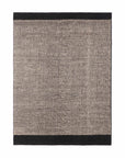 The Dots Kilim Rug by Ethnicraft is a handwoven rectangular piece featuring a textured gray center and solid black borders. Its minimalist design brings elegant style to any space.