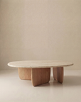 The Eden Coffee Table | Wood & Stone by Wooden Stories features a smooth Carrara marble top and three curved solid American oak legs, showcased against a plain beige background.