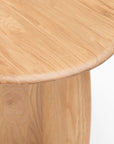 Close-up view of the Eden Side Table by Wooden Stories, featuring a round, light solid wood top with a smooth natural finish and visible grain, exemplifying Scandinavian simplicity against a white background.