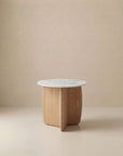 The Eden Side Table | Stone Top by Wooden Stories features a white marble top and light American oak base with intersecting curved panels, embodying Scandinavian simplicity against a beige backdrop.
