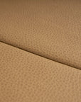 Close-up of light brown leather upholstery with a subtle texture and diagonal seam, showcasing the refined details of the contract-grade Hover Bench | Leather Seat by Wooden Stories.