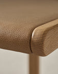Close-up of Wooden Stories' Hover Bench | Leather Seat: solid oak corner with textured tan leather top, highlighting fine grain and smooth rounded edges—ideal for contract grade furniture settings.