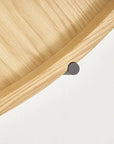 Close-up of the Humla Round Side Table by Wooden Stories, featuring light wood grain and Danish-inspired design. A black cylindrical metal support beneath the rim recalls classic Tray Tables, set against a plain white background.