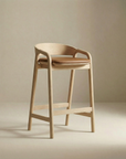 The Inlay Counter Stool | Leather Seat by Wooden Stories features a modern design with a curved backrest, padded leather seat, and clean lines, shown here against a plain beige background.