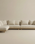 The Islet Modular Sofa | Fabric • M2 by Wooden Stories features light beige upholstery, multiple matching cushions, wooden legs, and a minimalist design, set against a neutral background.