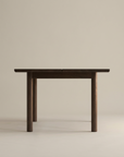 The Itamae Dining Table | Espresso Oak by Wooden Stories features a minimalist, flat rectangular top with four round legs in solid American Oak, inspired by Scandinavian design and shown against a plain beige background.