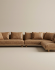 The Islet Modular Sofa | Leather • M2 by Wooden Stories is an L-shaped sectional in light brown leather with matching cushions and wooden legs, shown against a plain beige background.