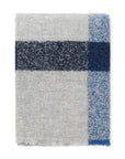 The Elvang Denmark Lava Throw - Cobalt Blue is a folded light gray alpaca wool throw with a wide dark blue stripe intersected by a lighter blue vertical stripe, featuring a textured, heathered pattern and classic Scandinavian design.