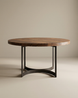 The SOBU Leviathan Round Dining Table features a thick acacia wood top with a natural finish and sleek metal legs, showcased against a plain beige background.