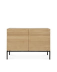 The Ethnicraft Ligna Sideboard - 2 door is a modern piece crafted from European oak in a light natural finish, featuring two wide top drawers, two cabinet doors below, and slender black metal legs.