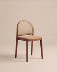 The Luk Dining Chair | Fabric Seat by Wooden Stories features a simple, minimalist design with a woven cane weave rattan backrest, and sits on a beige background, evoking the timeless style of the Danish Collection.
