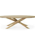 The Ethnicraft Mikado Coffee Table Oval - Oak features solid oak construction and a unique crisscrossed base, shown here against a white background.