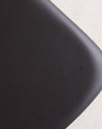 Close-up of the rounded, textured black leather seat cushion on the Noki Dining Chair by Wooden Stories, crafted in black oak—a detail reflecting its Japanese-inspired design.