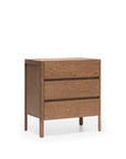 The Nell Tall Dresser by Wooden Stories, featuring three drawers with premium metal runners for smooth operation, is crafted from wood in the Danish Collection style. With its natural finish and minimalist clean lines, this dresser stands on four legs against a plain white background—an ideal choice for bedroom storage.