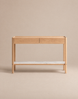 The Nell Console by Wooden Stories features solid light oak construction, two soft-close drawers, and a lower white stone shelf, showcased against a plain beige background.