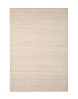 The Nomad Kilim Rug - Sand by Ethnicraft is a rectangular, light beige area rug, hand-woven from 100% sheep wool with a subtle horizontal linear texture, shown on a white background.
