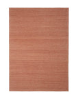 The Ethnicraft Nomad Kilim Rug - Terracotta is a rectangular sheep wool rug featuring a solid, muted terracotta hue with a subtle textured pattern, shown on a white background.