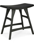 The Osso Dining Stool by Ethnicraft features a black oak frame with a leather seat, curved silhouette, and four angled legs with horizontal supports, blending modern design with classic European elegance.