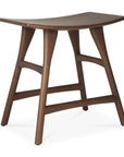 The Osso Dining Stool - Teak by Ethnicraft features FSC-certified teak in a smooth, dark finish. Its four-legged design with horizontal supports and a gently concave seat offers minimalist, modern style.
