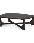 The PI Coffee Table - Mahogany - Pebble Shape by Ethnicraft features a modern low profile, rounded pebble-shaped top, and sculptural curved legs with diagonal supports in dark-stained mahogany.