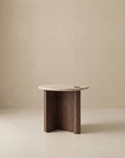 The Pivot Side Table | Wood & Stone by Wooden Stories features a small, round light solid oak top with three dark wood legs. Its minimalist, modern Danish design stands out against a neutral beige background.