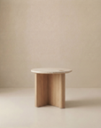 The Pivot Side Table | Wood & Stone by Wooden Stories, with a solid oak round top and three curved legs, from the Danish Collection, is shown against a plain beige background.