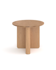 The Pivot Side Table by Wooden Stories is a round Danish-inspired side table in solid oak, featuring a flat top and an innovative base with one cylindrical leg and two intersecting panels in a light finish.