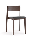 The Poise Dining Chair by Wooden Stories features an espresso oak finish, a straight backrest, cushioned leather seat, and four sturdy legs. Its simple modern design is inspired by the Danish Collection and built to contract grade standards.