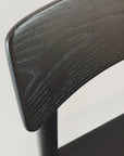 Close-up of the Cesco Dining Chair - Black Ash by SOBU, showcasing its classic design and dark ash wood grain. The smooth, curved backrest stands out against a light background, reflecting the chair’s solid engineering.