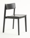 The Poise Dining Chair | Black Oak by Wooden Stories features a modern, straight-back design with four round legs in black oak, shown against a plain white background.