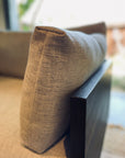 Close-up of a beige cotton-linen removable cover cushion on the armrest of the SOBU Woody Sectional Sofa in Espresso Ash and Fog, with soft natural light streaming through a window in the background.
