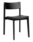 The Poise Dining Chair by Wooden Stories features a modern black oak frame with sleek Danish lines, a slightly curved back and seat, premium leather upholstery, and four straight legs.