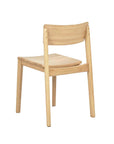 The Poise Dining Chair in Light Oak by Wooden Stories features a curved backrest and flat seat, shown from the rear and slightly to the side against a white background.