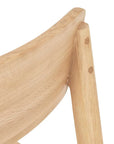 Close-up of the upper backrest and support of the Wooden Stories Poise Dining Chair in Light Oak, showcasing smooth natural wood grain and round joinery details.