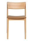 Front view of the Wooden Stories Poise Dining Chair | Light Oak with Leather, showcasing elegant Danish lines, a curved backrest, and a light brown padded leather seat, set against a plain white background.