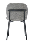 The Solace Dining Chair by Wooden Stories showcases a cushioned, textured gray fabric seat and backrest, black metal legs, and a horizontal black metal bar across the upper back for modern style.