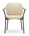 The Solace Dining Armchair | Leather by Wooden Stories is a modern chair with a beige cushioned seat and backrest, black metal legs, and light wooden armrests, shown front-facing against a white background.