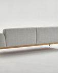The Department Sofa | Fabric by Wooden Stories is a modern light gray couch featuring a solid wood base and slim black metal legs, shown from the back against a plain white background.